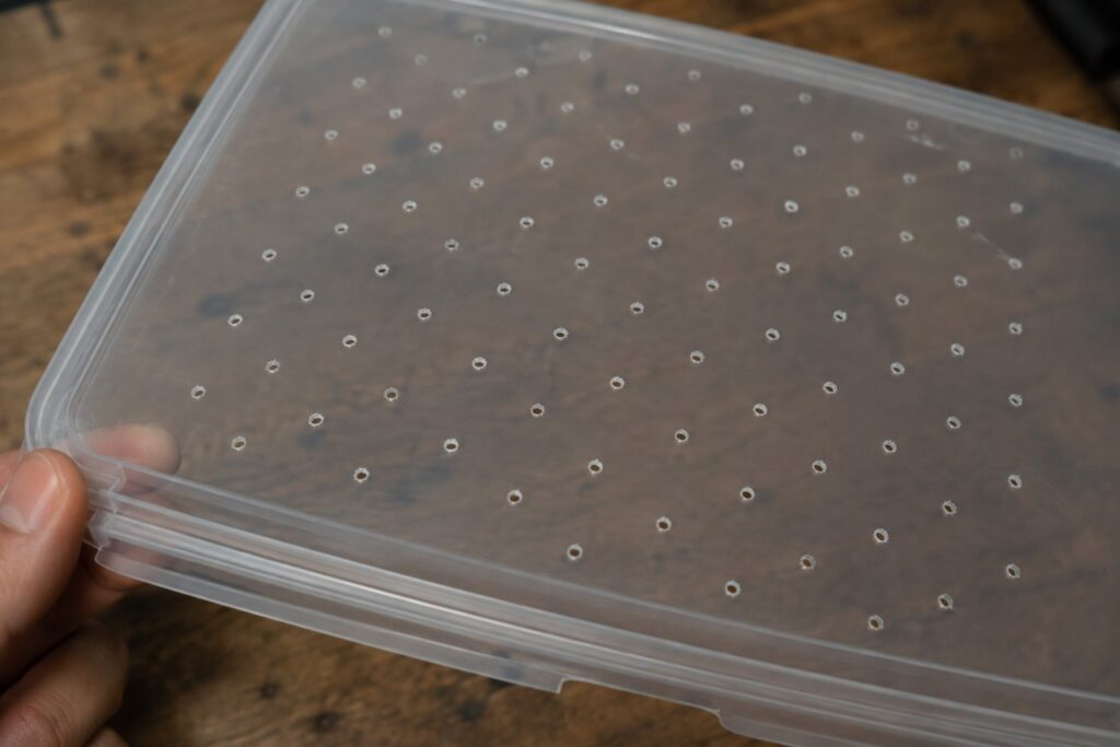 Ventilation holes drilled into a plastic storage bin lid for an isopod enclosure
